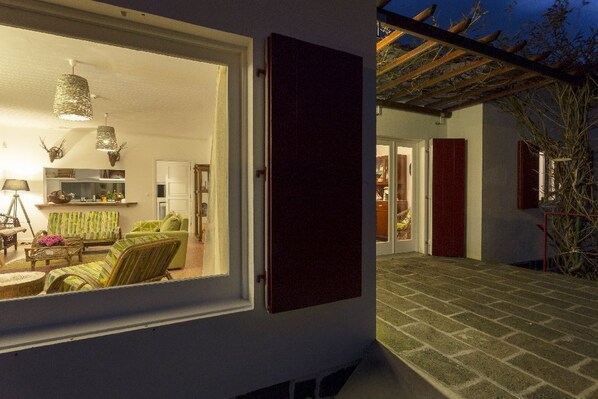 Vista interna de um quarto com área de refeições, cozinha e sala de estar.