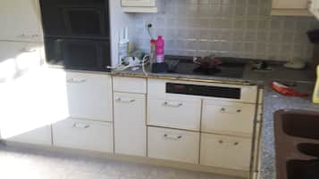 A kitchen with white cabinets, a black stove, and a tiled backsplash.