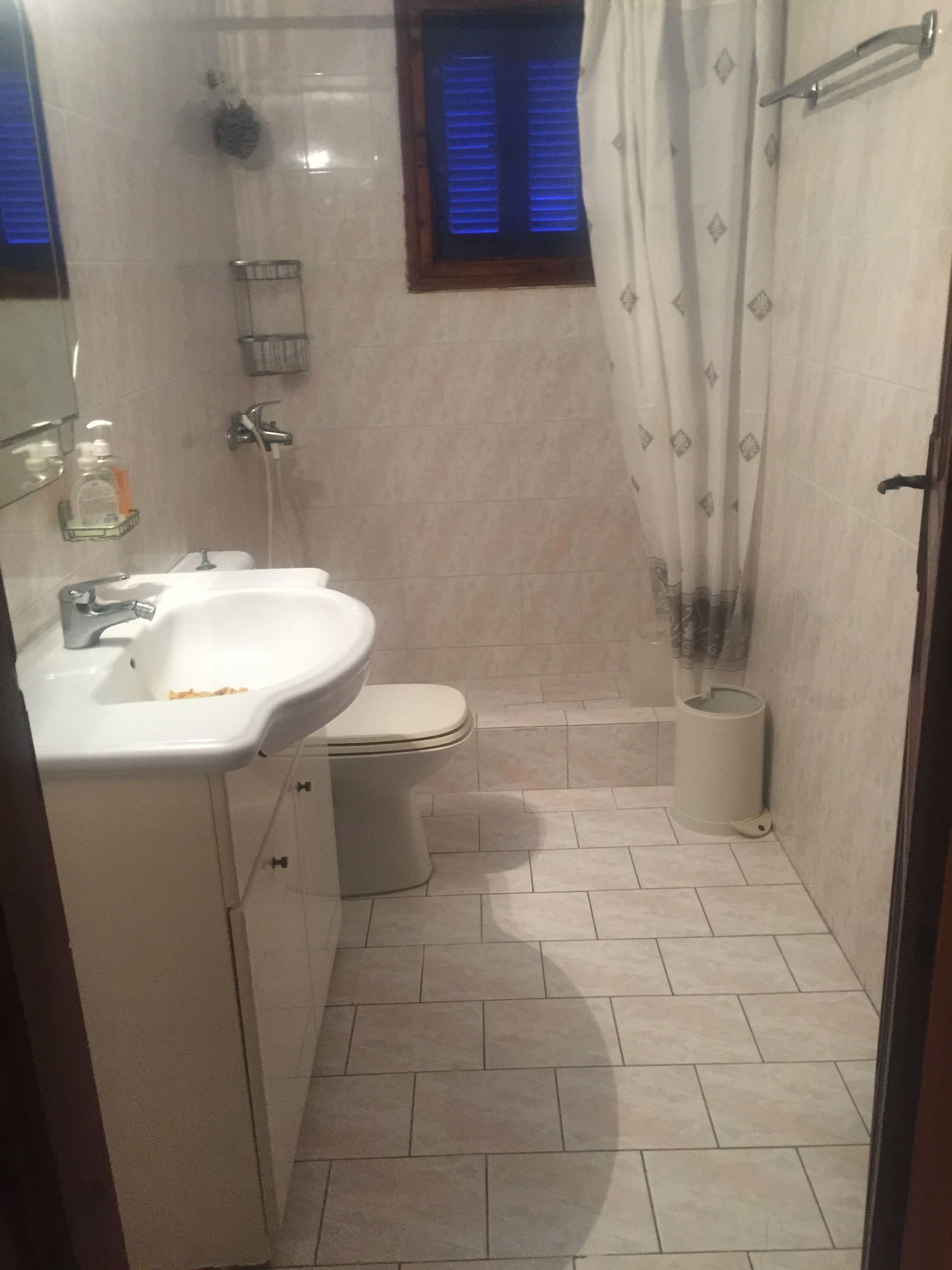 Un baño pequeño con lavamanos, inodoro y ducha.