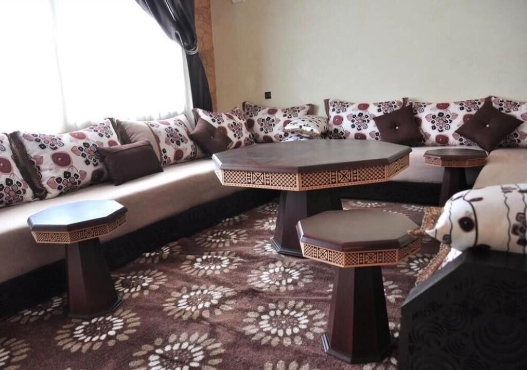 A seating area with a sofa and two round tables, each with a geometric patterned base.