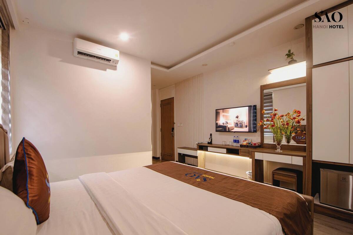 Une chambre d’hôtel équipée d’un lit, d’un bureau, d’une télévision et d’un appareil de climatisation.