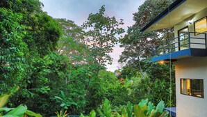 Un edificio moderno con un balcón que da a un exuberante jardín.