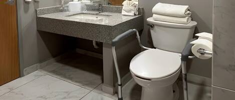 A bathroom with a toilet, a sink, and a shower.