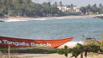 A beach with a boat labeled "Tangalle Beach" and houses in the background.
