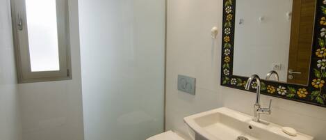Ein Badezimmer mit Toilette, Waschbecken und Dusche.