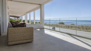 Un balcón amplio con vistas despejadas al mar y un paisaje urbano lejano.