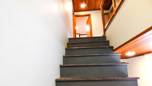 A staircase with wooden handrails and a dark-colored riser. - Flats Requinte Gramado (Gramado)