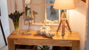 Ein Holzkonsolentisch mit Lampe, Dekoration und Spiegel.