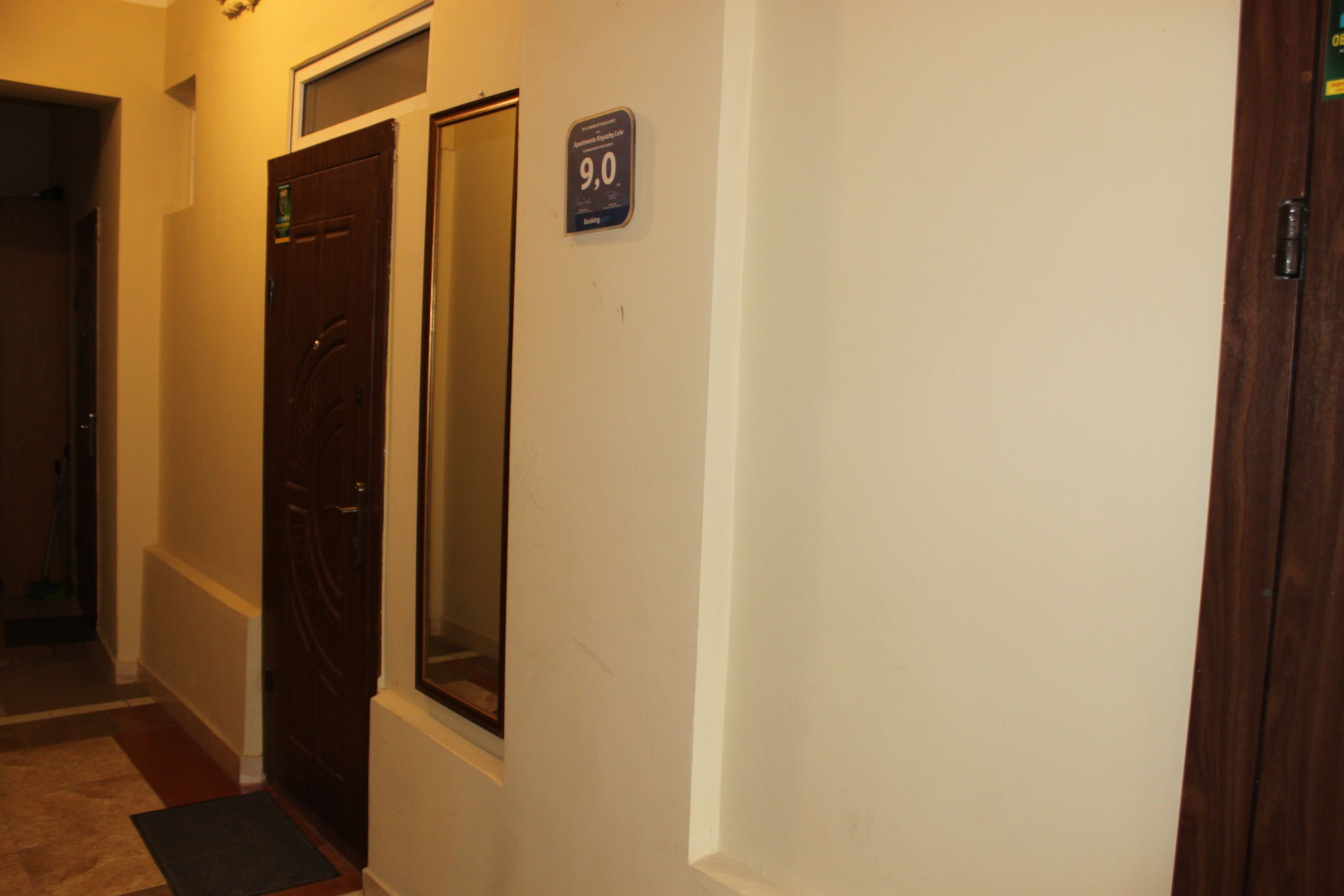 Un pasillo con dos puertas, una de ellas marcada con un letrero que indica el número de habitación 9.0.