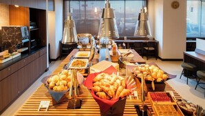 A buffet setup with various food items and a modern interior design. - Super Hotel Yamagata Tsuruoka (Tsuruoka)