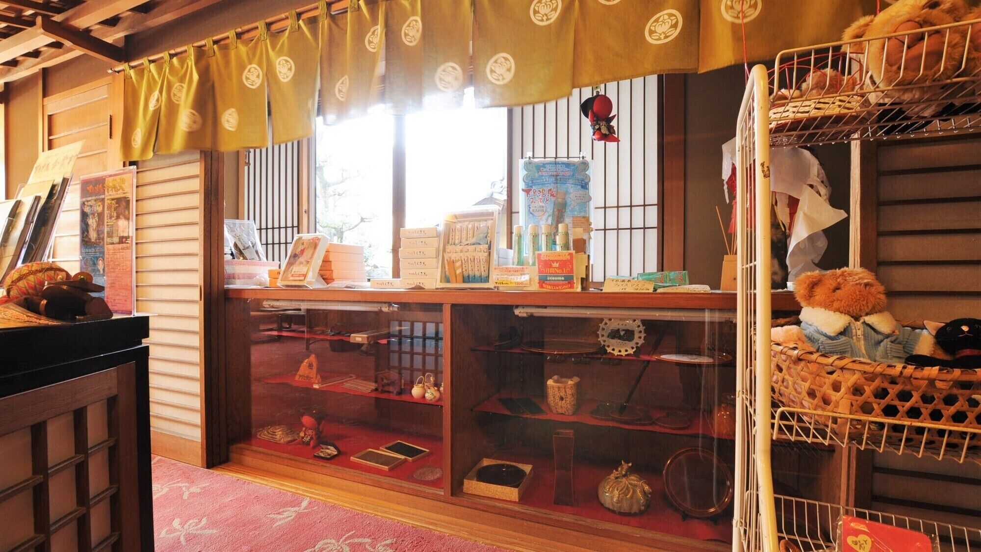 Ein traditioneller japanischer Raum mit Tatami-Bodenbelag, einer Schiebetür und einem Regal mit verschiedenen Gegenständen.