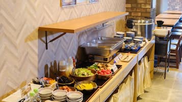 A buffet setup with various food items and condiments.