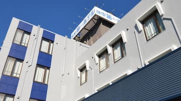 A multi-story building with a flat roof and a sign indicating a business or service on the top floor.