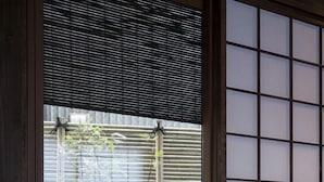 Een traditionele Japanse kamer met tatami vloeren, shoji schermen en een bamboe plant.