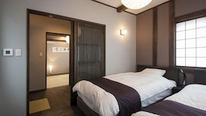 Een hotelkamer met een bed, een raam, een deur en een lamp.