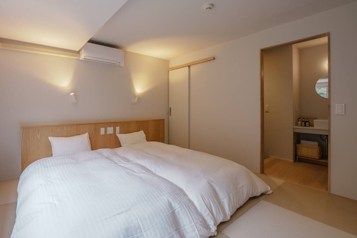 Ein Schlafzimmer mit einem großen Bett, einem Fenster, einer Klimaanlage und einem Kleiderschrank.