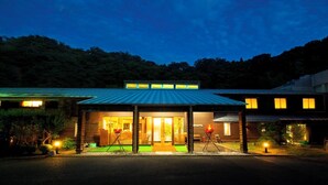 A modern building with a covered entrance, a visible outdoor seating area, and a fire pit. - Mimata Onsen Nagomi Yuyado Kanagi (Hamada)