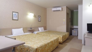 A hotel room with two beds, a desk, a television, and an air conditioning unit. - Family Lodge Hatagoya Mito Oarai (Mito)