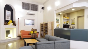 A hotel lobby with a reception desk, a sofa, a table, and a fireplace with teddy bears. - Family Lodge Hatagoya Mito Oarai (Mito)