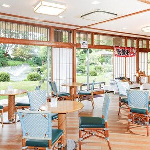 Un restaurant traditionnel de style japonais, doté d’un sol recouvert de tatamis, de meubles en bois et de grandes fenêtres donnant sur un jardin.