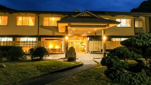 A two-story building with a covered entrance and a well-maintained garden. - Ichinomata Onsen Grand Hotel (Shimonoseki)