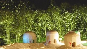 Paisaje desértico con tres pequeñas estructuras en forma de cúpula.