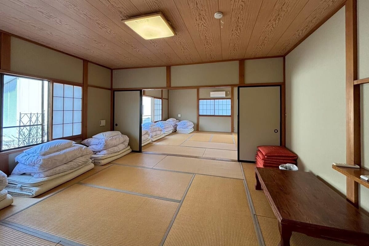 Une pièce de style japonais traditionnel, avec un sol recouvert de tatamis, un plafond en bois et des portes coulissantes.