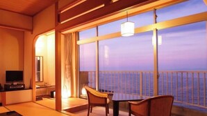 A room with a view of the sea, a table, chairs, a TV, and a lamp. - Boyokaku (Amakusa)