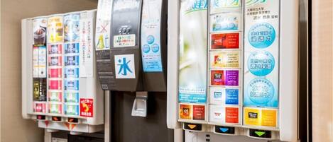 Una hilera de dispensadores de bebidas con distintas opciones y etiquetas promocionales.