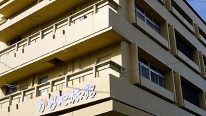 Een meerlaags gebouw met een beige gevel en een bord met Japanse tekens.