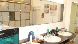 Een badkamer met twee wastafels, een spiegel en een douchehoek.