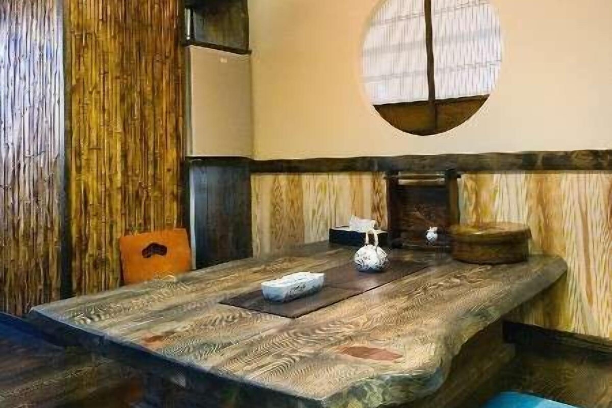 Ein traditioneller japanischer Raum mit Tatami-Bodenbelag, einem niedrigen Tisch und einem Shoji-Bildschirm.
