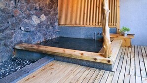 Eine Steinmauer mit einer Holzbank und einer Holzkonstruktion mit einer Leuchte.