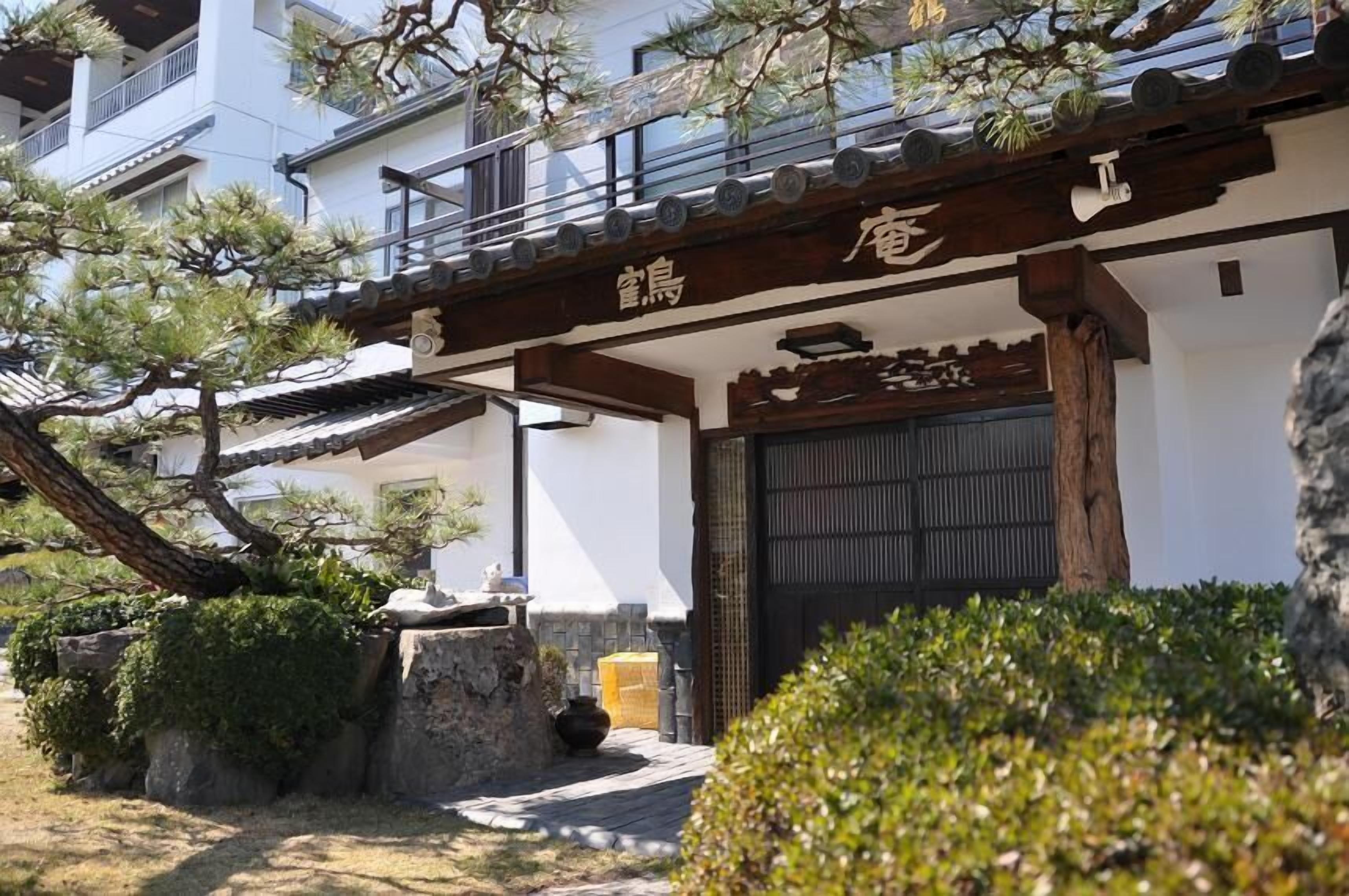 A traditional Japanese building with a wooden entrance and a tiled roof.