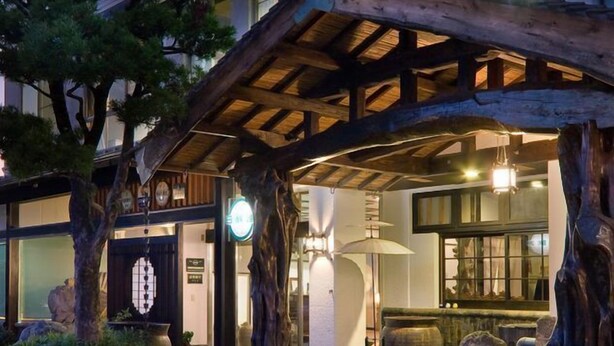 Ein traditionelles japanisches Gebäude mit Holzfassade und überdachter Eingangszone.