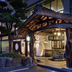 Ein traditionelles japanisches Gebäude mit Holzfassade und überdachter Eingangszone.