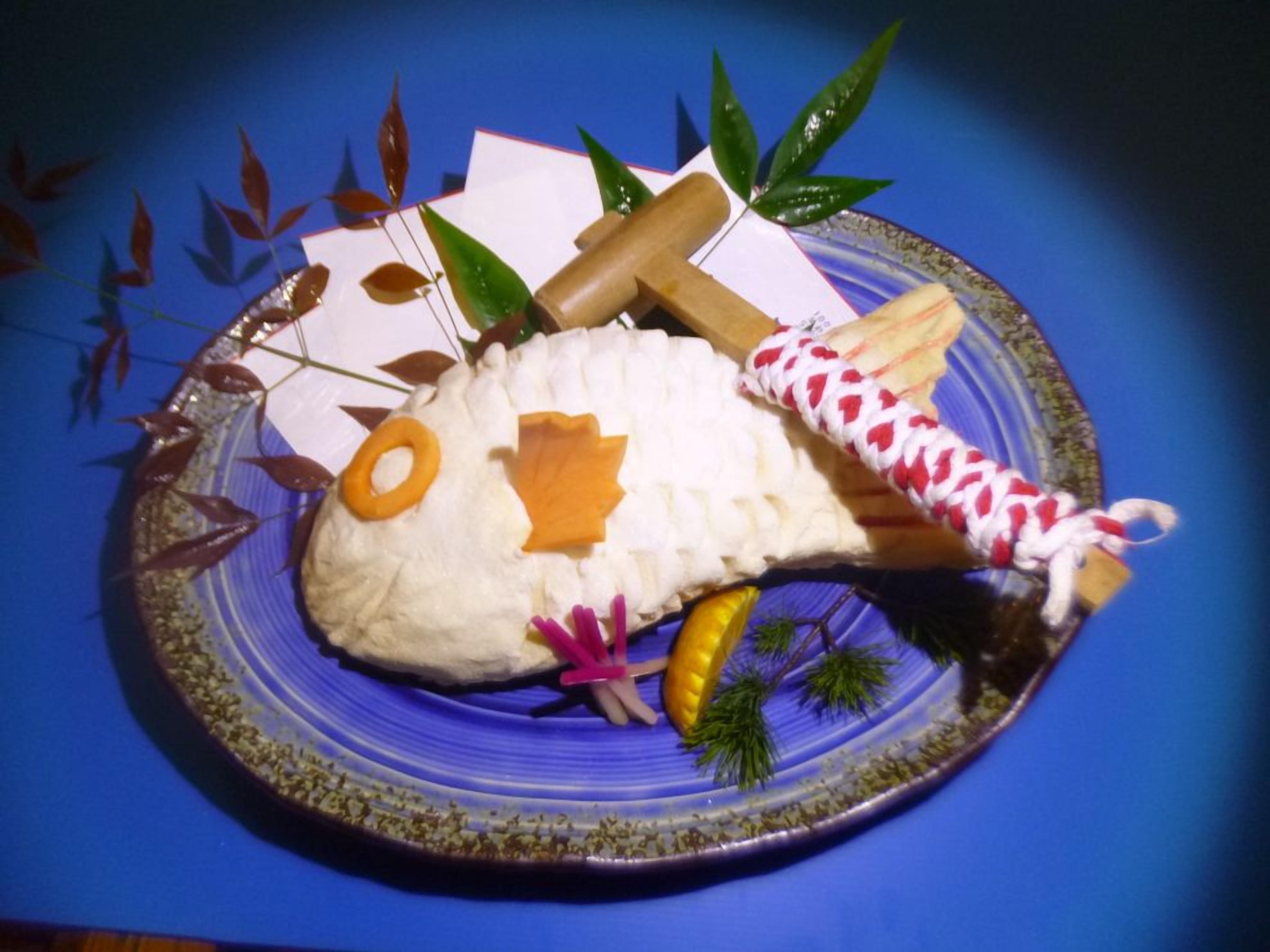 A decorative fish sculpture on a plate with a blue background.