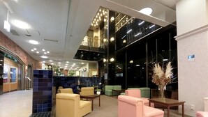 Ένας χώρος υποδοχής με καθιστικά, ένας πάγκος υποδοχής και ένα μεγάλο παράθυρο.