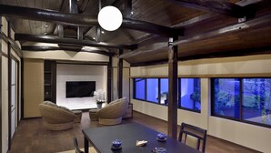 Una habitación de estilo japonés tradicional con suelo de tatami, una mesa baja con juegos de té y una chimenea.
