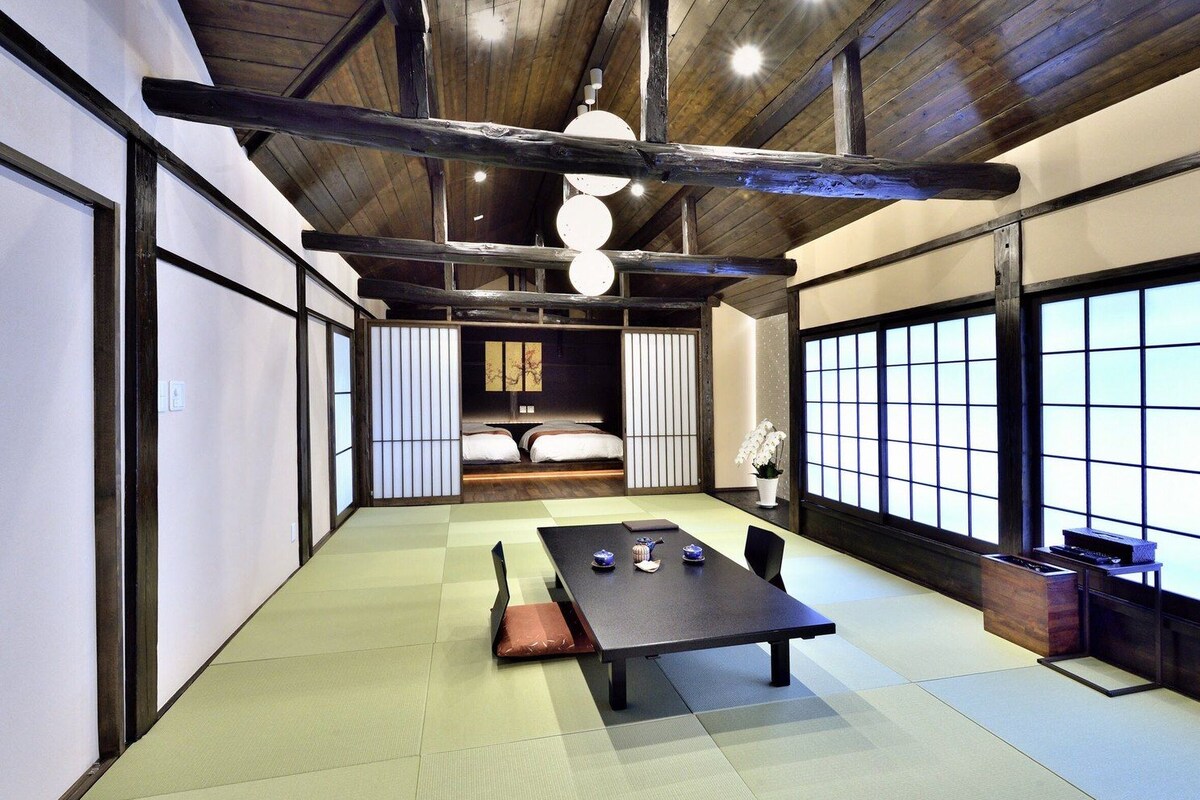 Una tradizionale stanza in stile giapponese con pavimento in tatami, un tavolino basso e un futon.