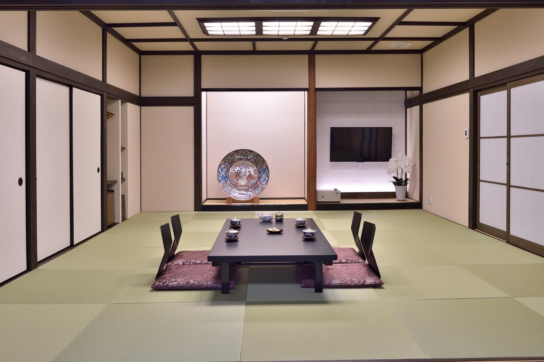 Una habitación japonesa tradicional con suelo de tatami, una mesa baja de tatami y puertas correderas shoji.