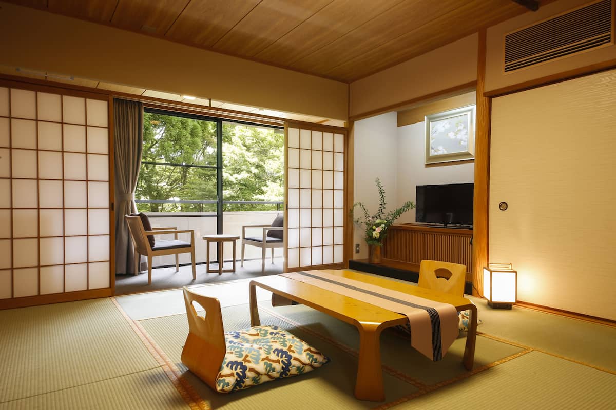A traditional Japanese room with tatami flooring, a low table, and sliding doors.