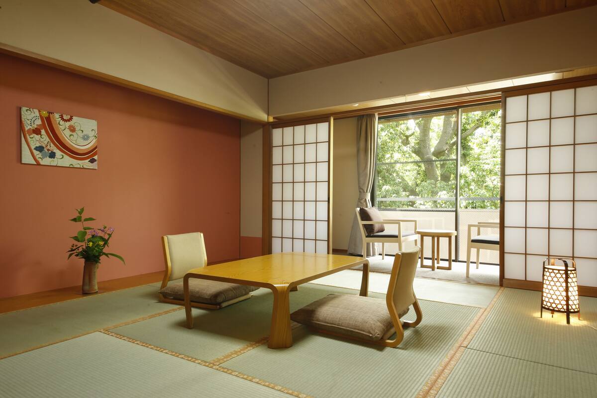 A traditional Japanese room with tatami flooring, a low wooden table, and shoji screens.