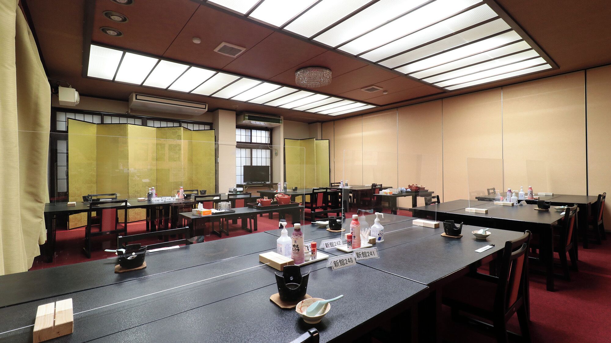 A conference room with long tables, chairs, and a ceiling with skylights.