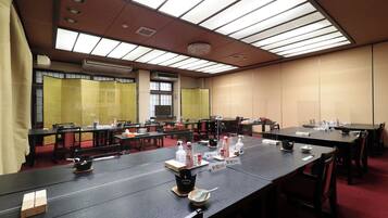 A conference room with long tables, chairs, and a ceiling with skylights.