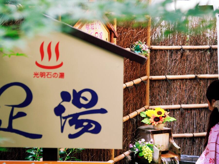 Un edificio japonés tradicional con un letrero que muestra caracteres japoneses y un símbolo rojo.