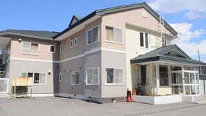 Un immeuble résidentiel de deux étages doté d’un balcon, de grandes fenêtres et d’un porche couvert.