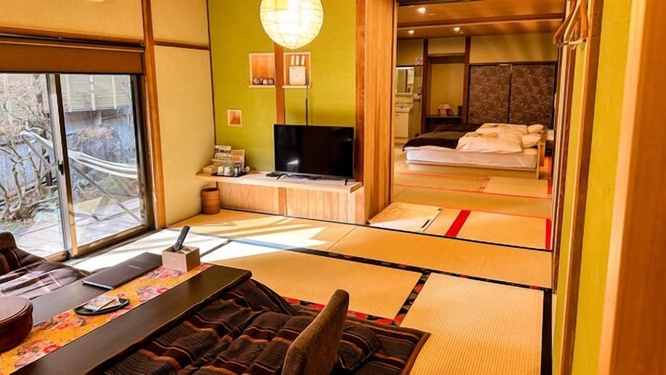 Perinteinen japanilaistyylinen huone, jossa on tatamimatto, televisio ja sänky, jossa on futon-patjat.