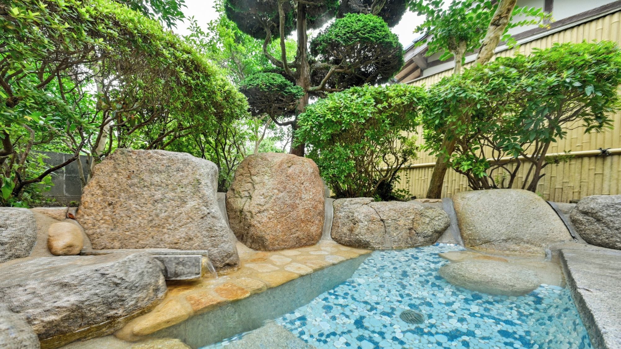 A rock garden with a small water feature and a pool.