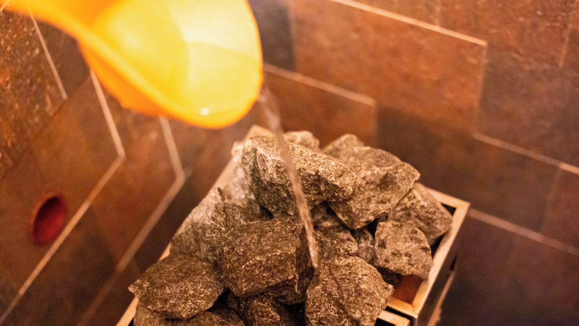 A pile of rocks in a corner with a yellow object above them.